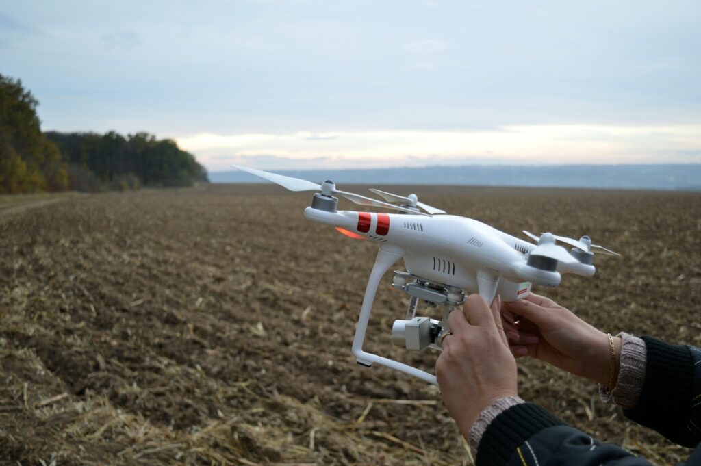 person holing a drone in a farm